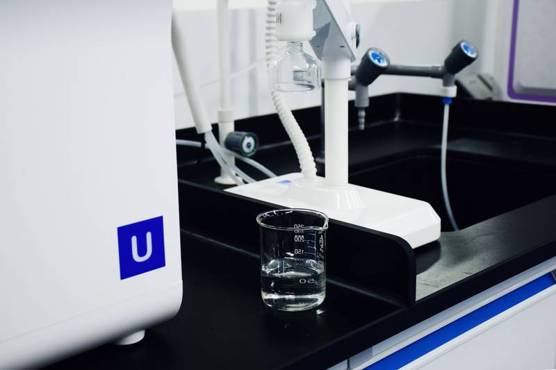 Close-up of modern laboratory equipment including a glass beaker and apparatus in a professional lab setting.